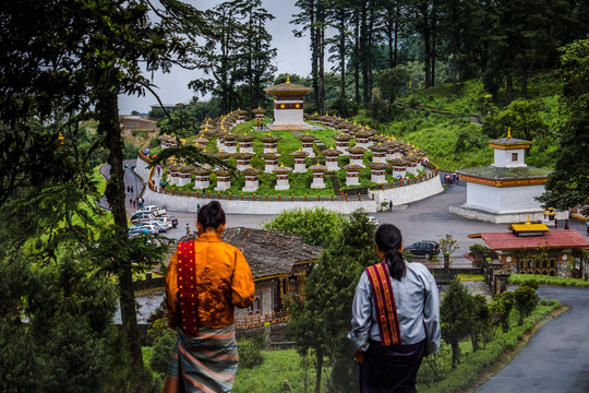 Women walking down the steps in front of chortens in Dochula pass, Bhutan