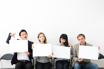 Group of people showing white boards.