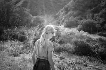 Black and white young girl hikes in forest on sunny day