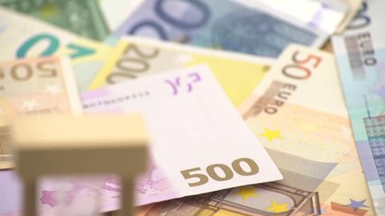 4K Dolly sliding shot of sand hourglass with euros banknotes of different values. Euro cash money background. glass clock standing on the bills. Time to crisis concept -Dan - Powered by Adobe