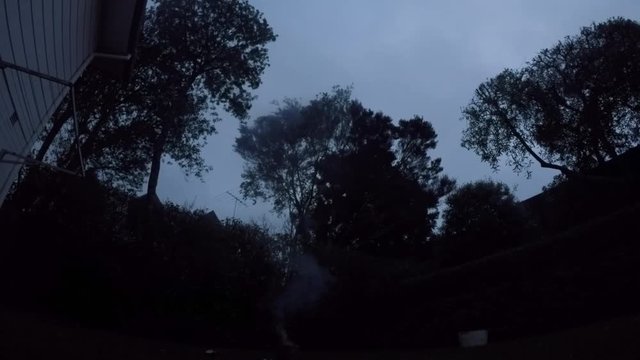Man launching fireworks explosive pyrotechnic in slow motion in home back yard.  Real people. Copy space