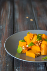 Salad with pumpkin, walnuts and green leaves