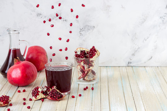 Pomegranate juice and fruit slices. Grains are flying over the glass. The concept of levitation