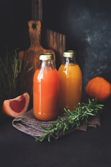 Fresh citrus juice in bottle. Grapefruit and orange fresh juice with pulp, healthy detox drink. Selective focus, toned image