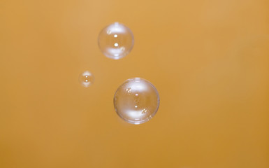 Soap bubbles on an orange background. Two soap bubbles with glare of light