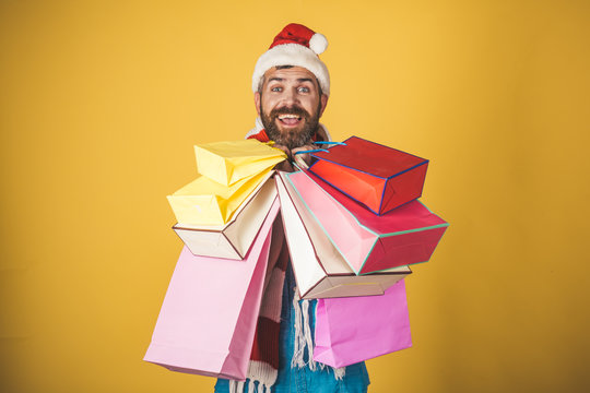 Christmas man hold shopping bags on yellow background