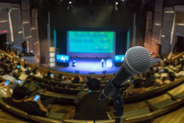 Microphone with Abstract blurred photo of conference hall or meeting room with attendee background, business and education concept