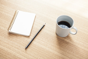 note, pencil, coffee on the wood table at the daylight.