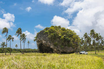 Car stands next to Tsunami Rock, Tongatapu, Tonga