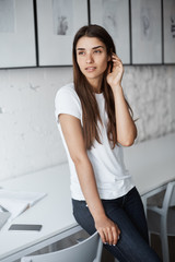Portrait of young lady in bright campus library looking off camera thinking about future plans.