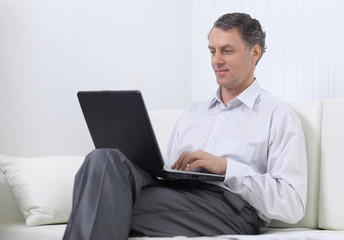 successful business man working on laptop sitting on sofa