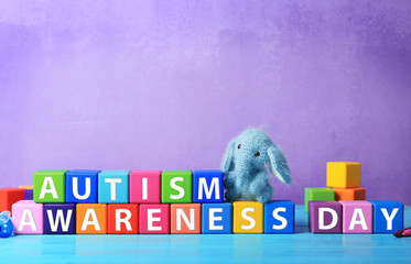 Cubes with text AUTISM SPECTRUM DAY on table