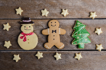Festive Christmas Cookie and New Year in the shape of Christmas tree, Gingerbread man, snowman, Snowflake, star on wooden table