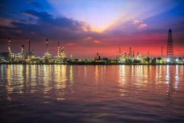 Naklejka premium Oil and gas industry - refinery at Sunrise - factory - petrochemical plant with reflection over the river