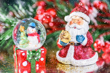 A Santa Claus and snowman in a snow globe arranged for a festive Christmas scene