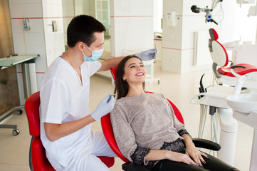 The dentist is treating teeth with a beautiful girl.