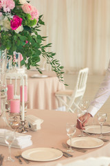 a man a waiter, a restaurant employee serves a festive wedding banquet table before dinner, puts a glass