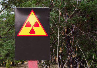 Sign radiation hazard in the forest. The radioactivity! The area is covered by radiation. Place for inscription.