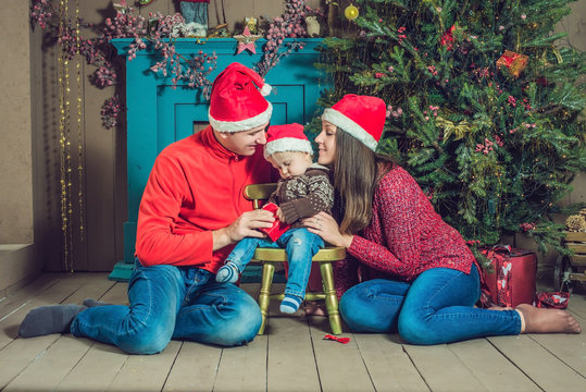 Happy family celebrates Christmas. Mom, Dad and Son in Christmas Decorations