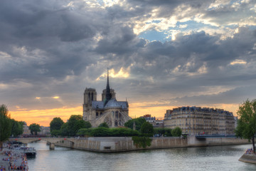 Notre Dame cathedral in Paris, France at dusk. Scenic skyline with dramatic sunset sky. Travel background.