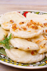 Dumplings, filled with potato and served with salty caramelized onion. Varenyky, vareniki, pierogi, pyrohy - popular dish in East Europe. View from above, vertical