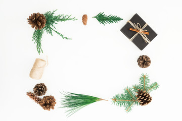 Christmas frame made of gift box, branches of tree and pine cones on white background. New year composition. Flat lay. Top view