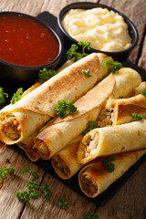 taquitos with chicken and cheese close-up, as well as sauces. vertical