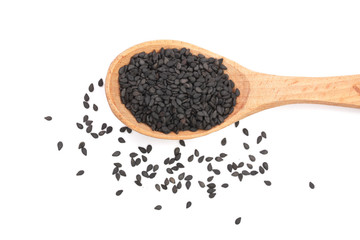 Black sesame seeds in a wooden spoon isolated on white background top view