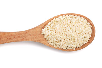 Sesame seeds in a wooden spoon isolated on white background top view
