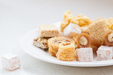 variety of honey oriental sweets in a white plate