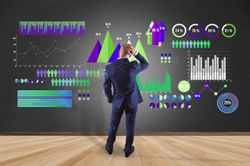 Businessman in front of a wall with a Business interface with chart graph and stats - Business and financial concept