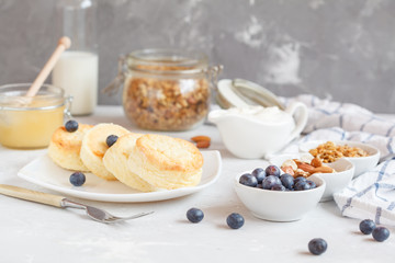 curd cheese cakes and granola with honey, yogurt, sour cream and milk