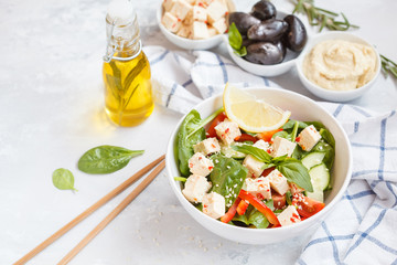 Vegan healthy salad with paprika tofu, hummus and olives
