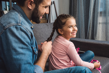 father making hair braid for daughter