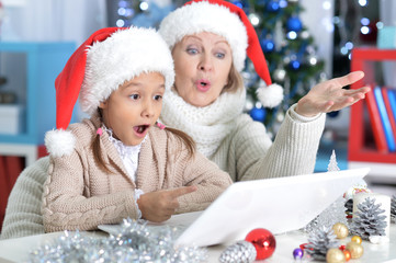  grandmother and her granddaughter using laptop 