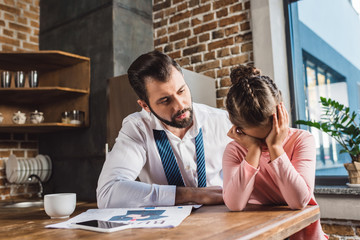 father trying to support crying daughter