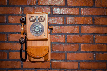 Urban background of a brick wall with an old out of service payphone