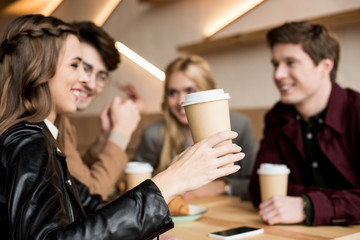 Girl holding paper cup of coffee