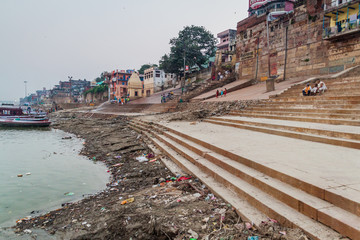 Fototapeta na wymiar VARANASI, INDIA - OCTOBER 25, 2016: View of a Ghat (riverfront steps) of sacred river Ganges in Varanasi, India