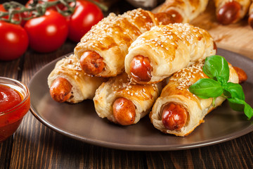 Rolled hot dog sausages baked in puff pastry - obrazy, fototapety, plakaty