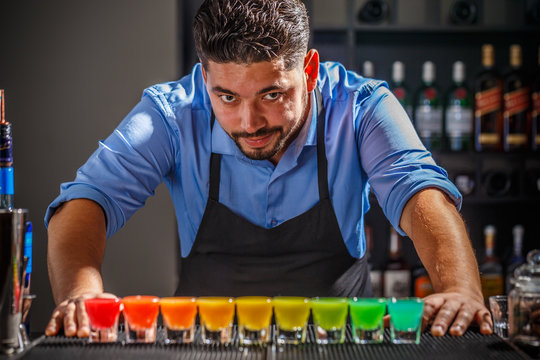 Barman with rainbow cocktai