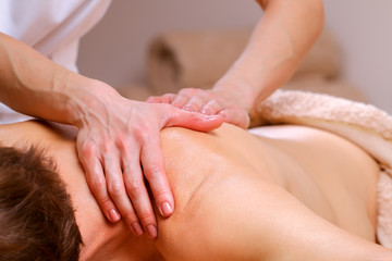 Fototapeta na wymiar Massage therapist massaging shoulders and back of a male