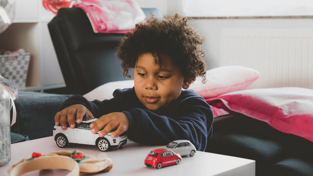 African American Kid Playing With Toy Car At Home