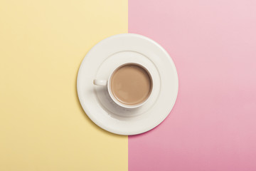 A cup of coffee on the color paper background.