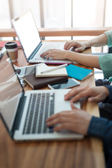 Young hipster worker typing on laptop keyboard in office