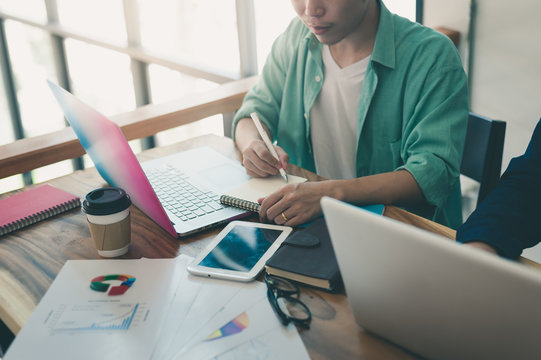 Asian man writing text on notebook