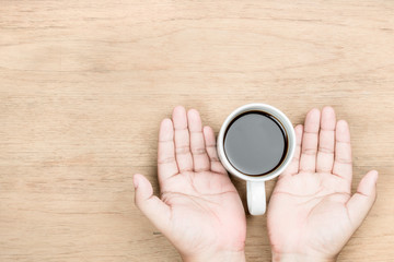 hand and coffee on table