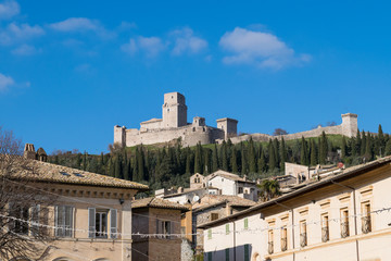 Fototapeta na wymiar View of the Rocca Maggiore Fortress over the rooftops of Assisi, Umbria, Italy