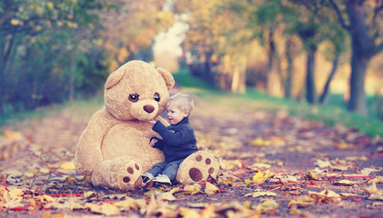 Kind mit seinem Teddy im Park