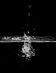 stream of bubbles under water on a black background